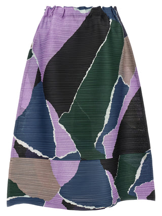 A pleated A-line skirt featuring an abstract geometric patchwork pattern in purple, dark green, navy blue, black, and beige, with white textured outlines separating the shapes.